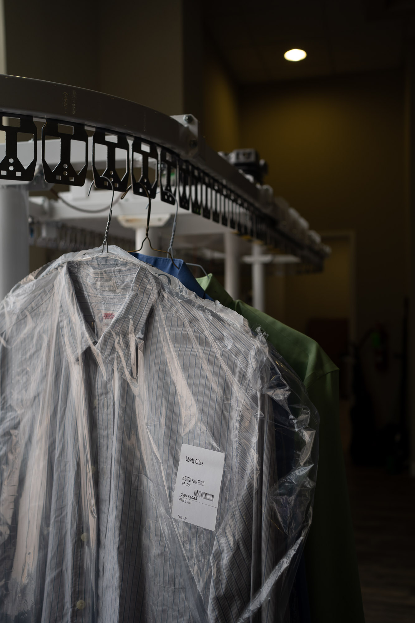 Dry cleaning conveyor system with bagged clothes on it.